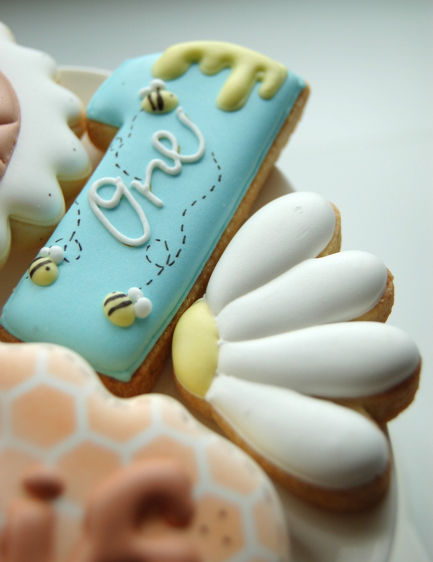 Biscuits marguerite et étiquette bleue décorée de petites abeilles pour un premier anniversaire