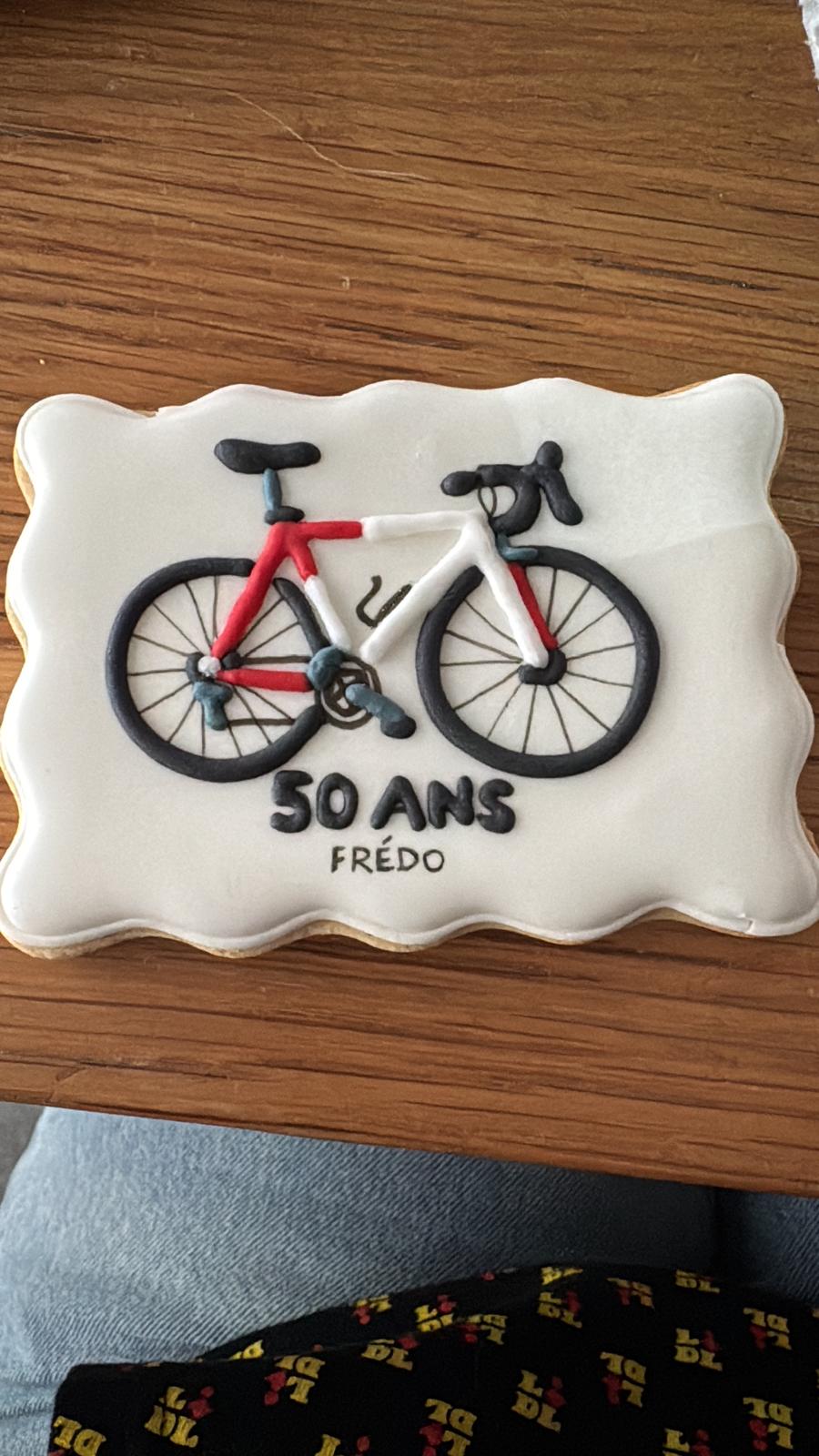 Biscuit rectangulaire décoré d'un vélo de course rouge et noir, avec la mention 50 ans et le prénom