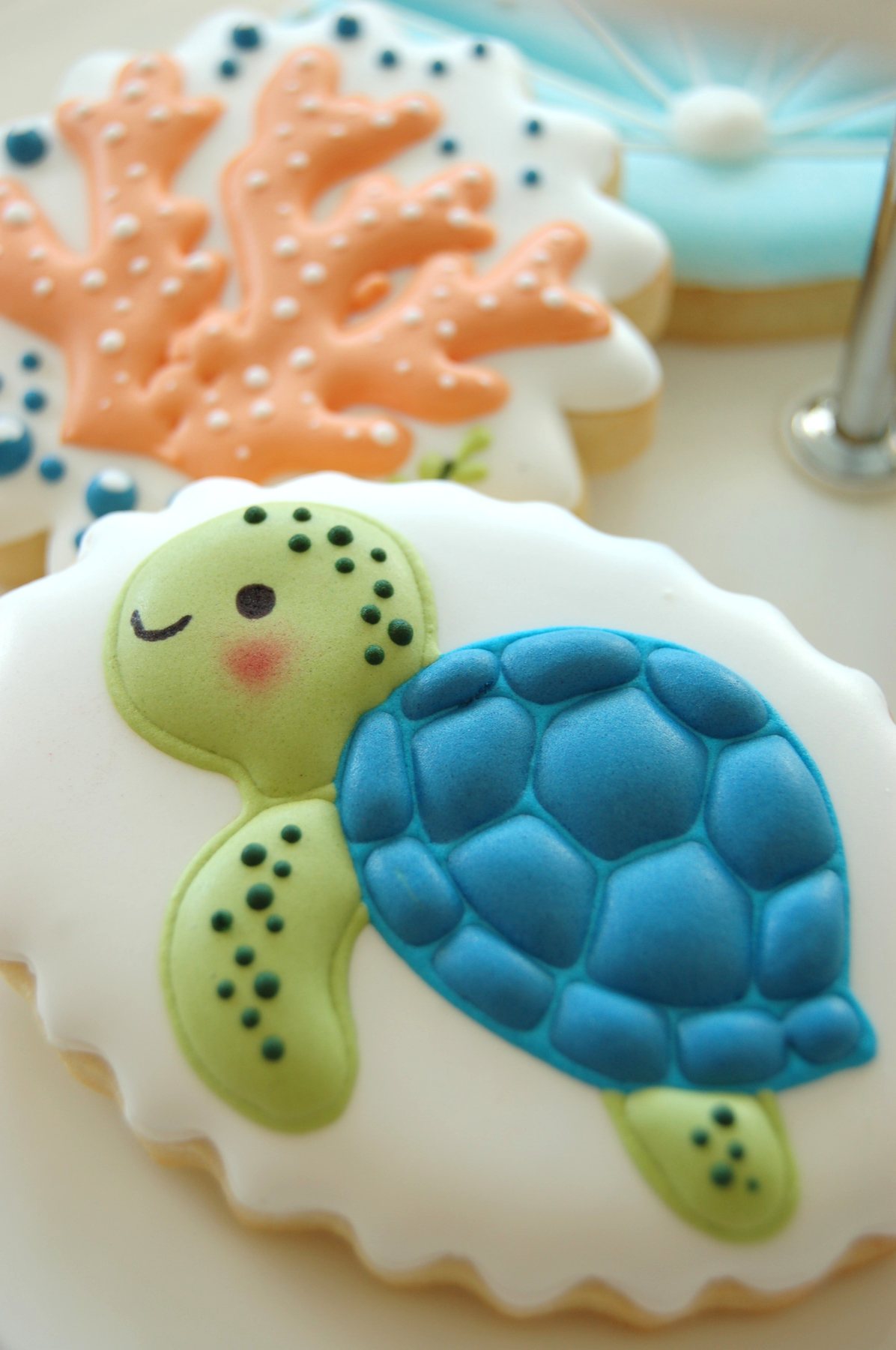 Biscuits tortues de mer bleue et verte, décorés à la main sur fond blanc
