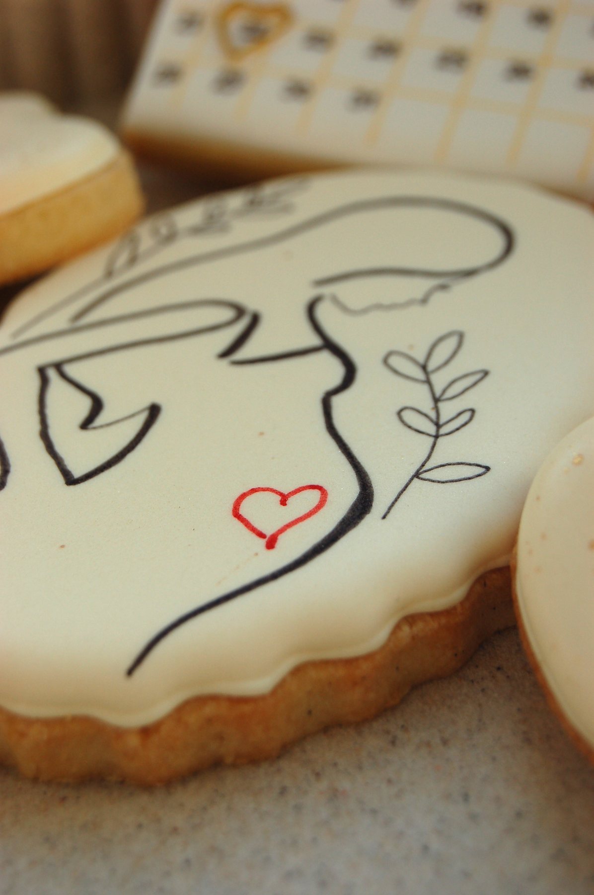 Biscuit line art représentant une silhouette dessinée d'un seul trait, avec un petit cœur rouge