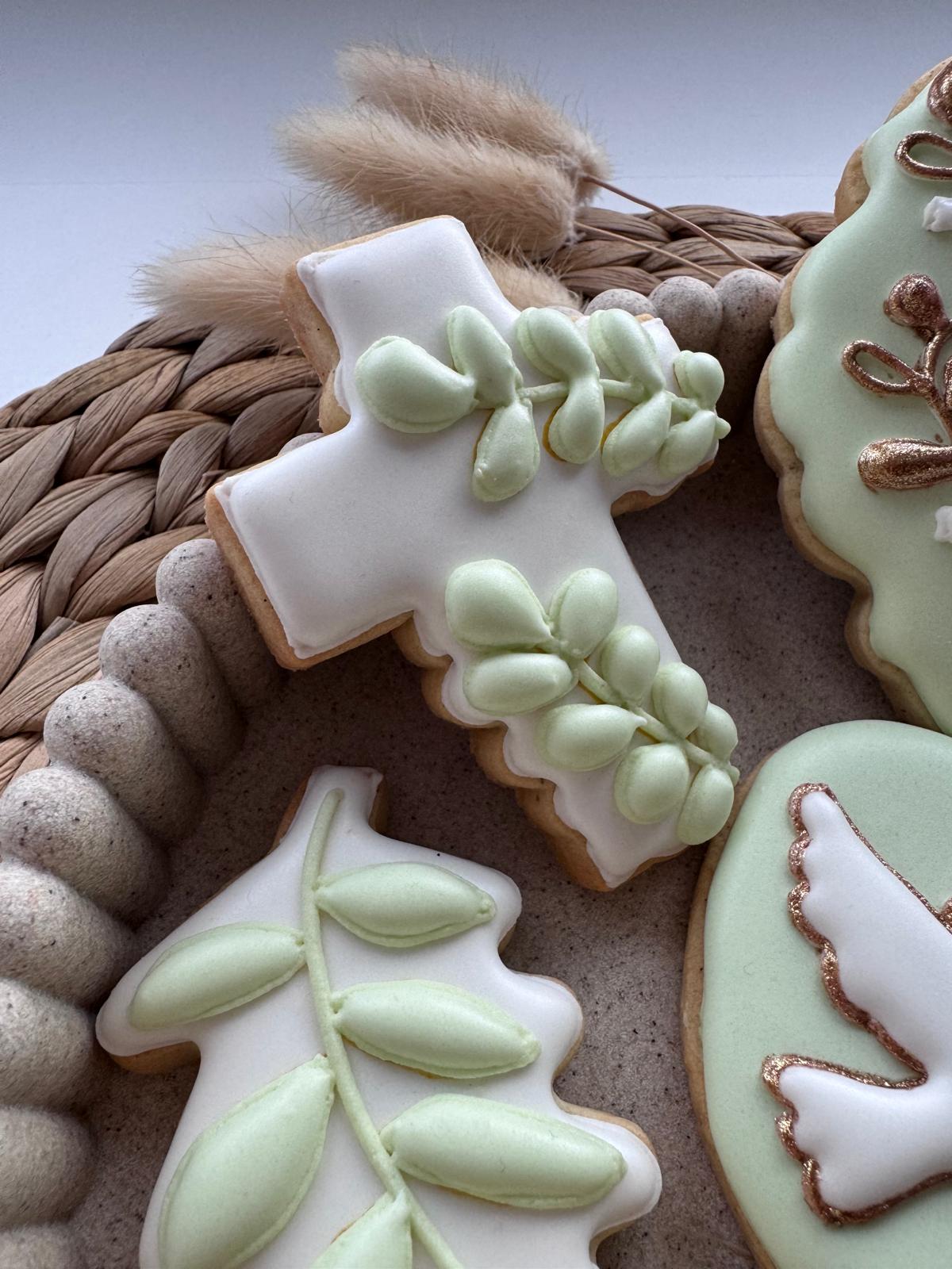 Biscuits croix et rameaux d'olivier posés sur un set de table en fibre naturelle