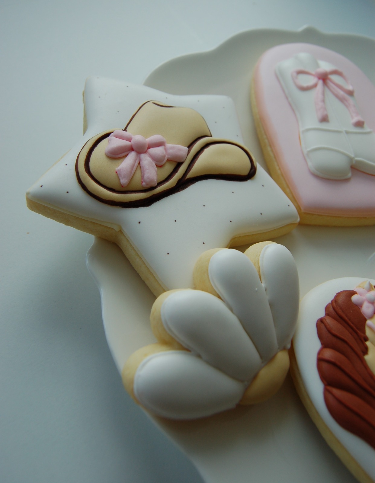 Biscuit étoile orné d'un chapeau de cow-boy et d'un nœud rose, avec une botte d'équitation