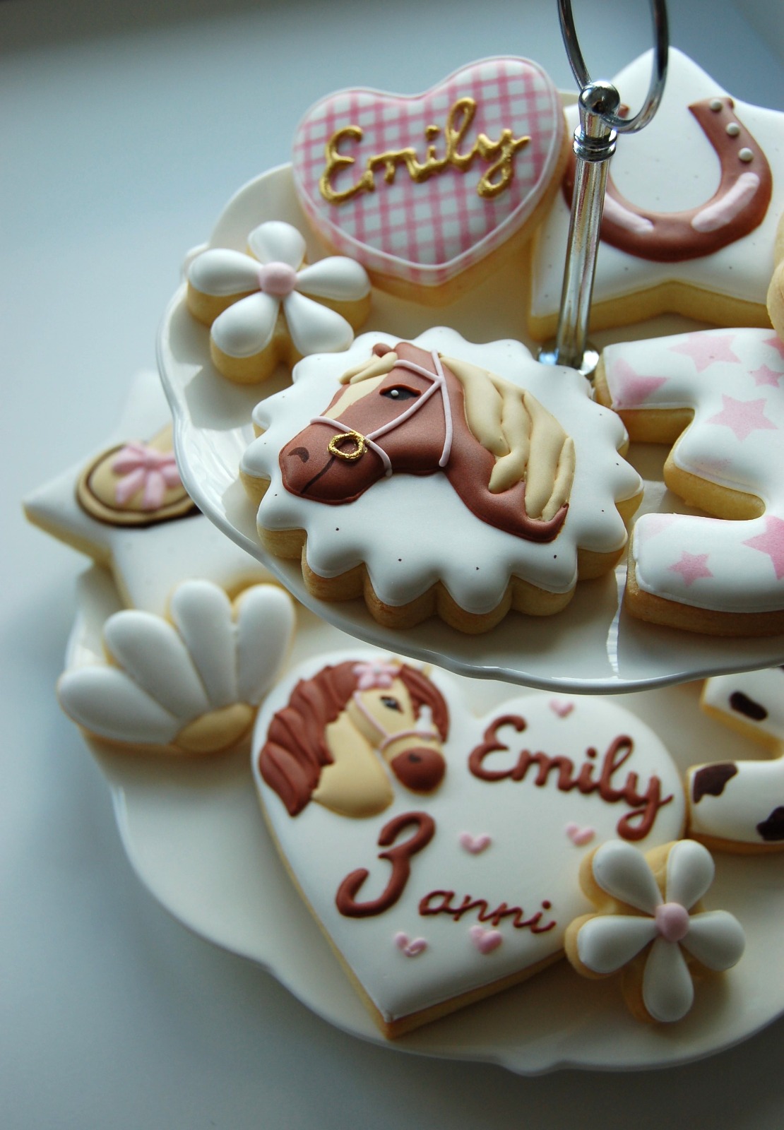 Biscuits cheval présentés sur une étagère : tête de poney, cœur au prénom Emily, marguerites et fer à cheval