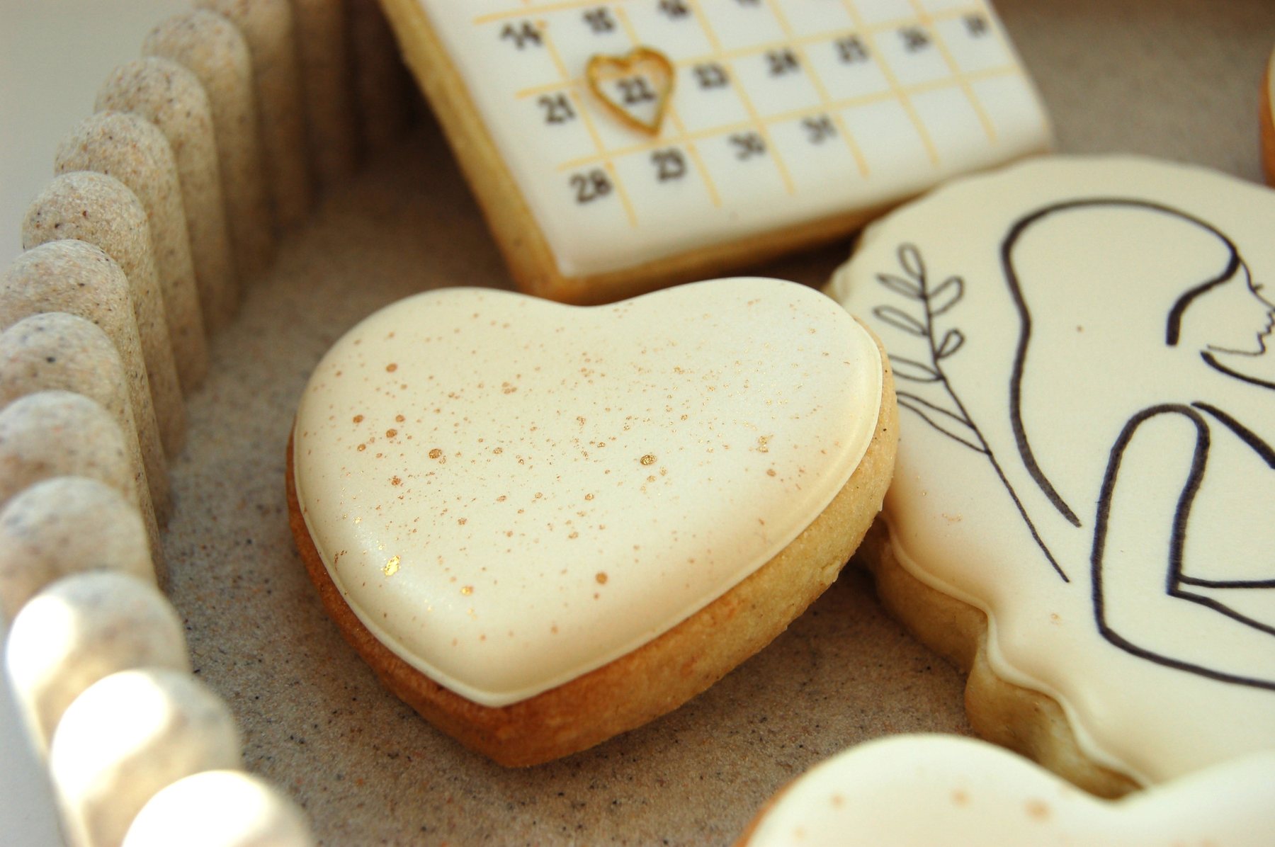 Biscuits cœur nature et biscuit calendrier posés sur un plateau clair