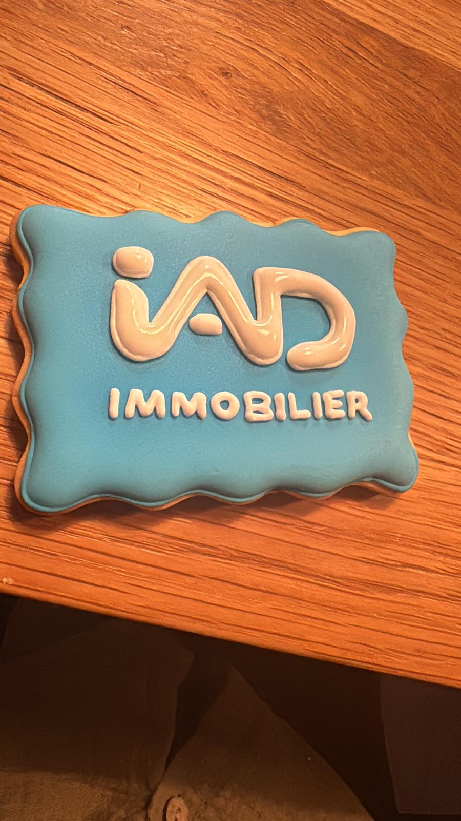 Gros plan sur un biscuit reproduisant un logo d'entreprise en glaçage bleu et orange