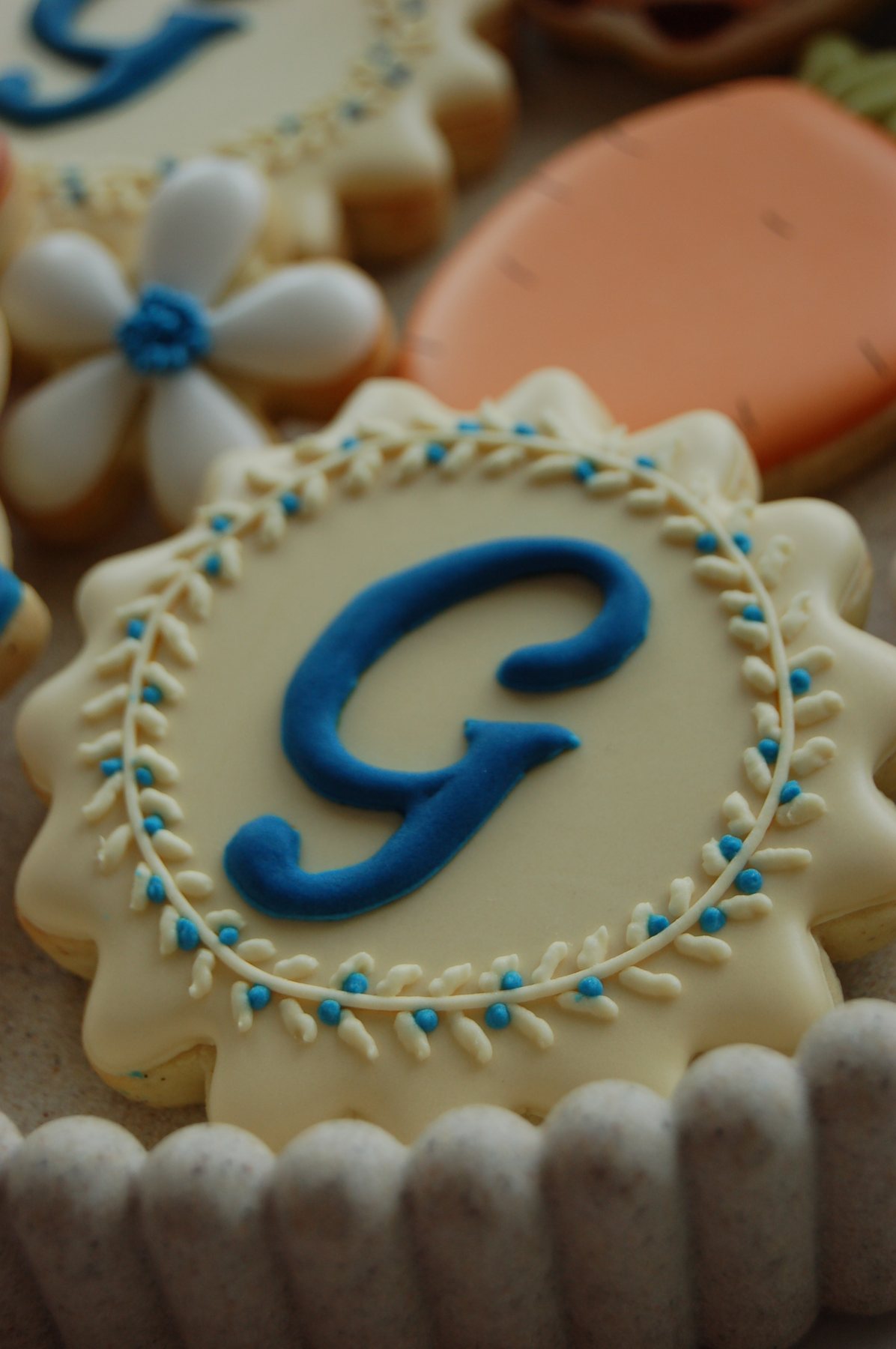 Biscuit médaillon au monogramme G bleu, encadré d'une couronne de petites fleurs