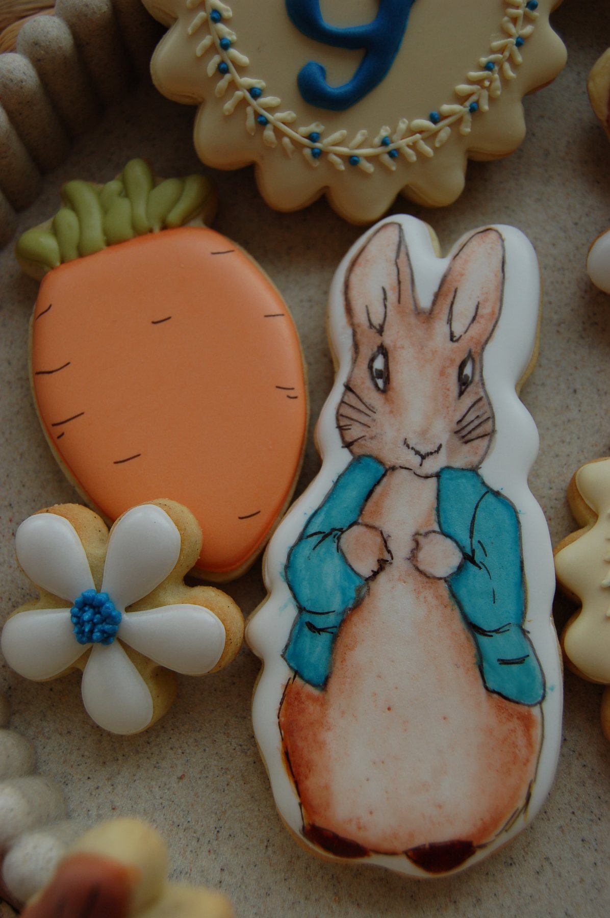 Biscuit lapin peint à la main, entouré de biscuits carotte et marguerite